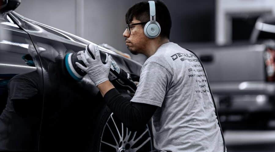 Professional paint correction being performed on a black car by a technician at Detail PHX in Phoenix, Arizona.